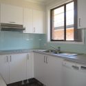 Glass Splashback behind the whole cooktop area and a colour matching Acrylic Splashback around the sink.
